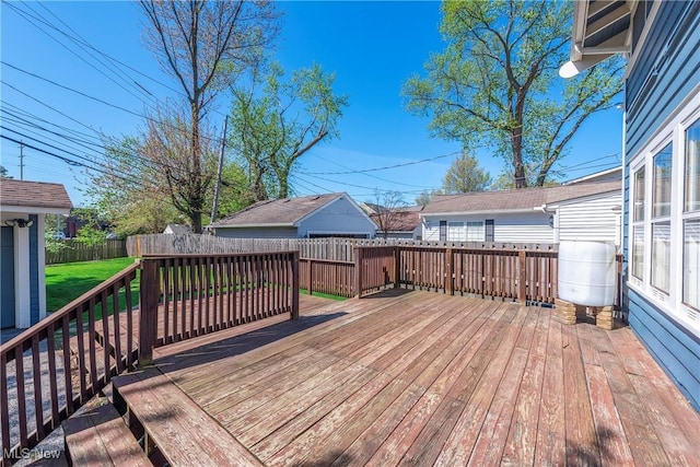 wooden terrace featuring a fenced backyard and a yard