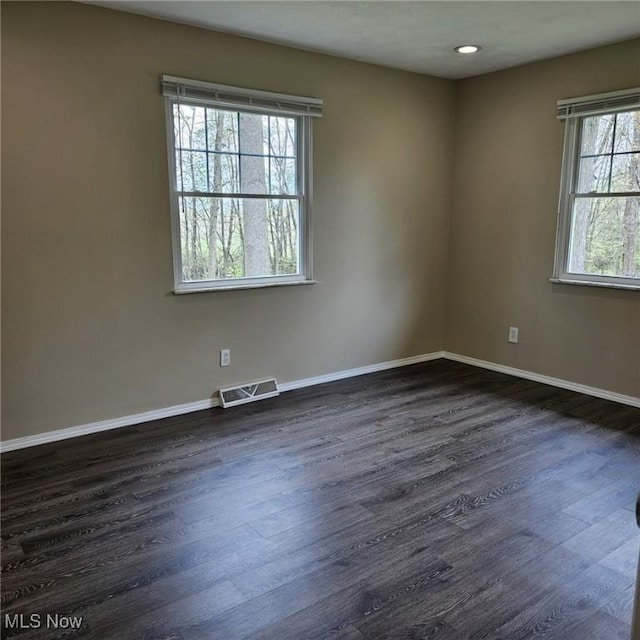 unfurnished room featuring baseboards, dark wood-type flooring, recessed lighting, and visible vents