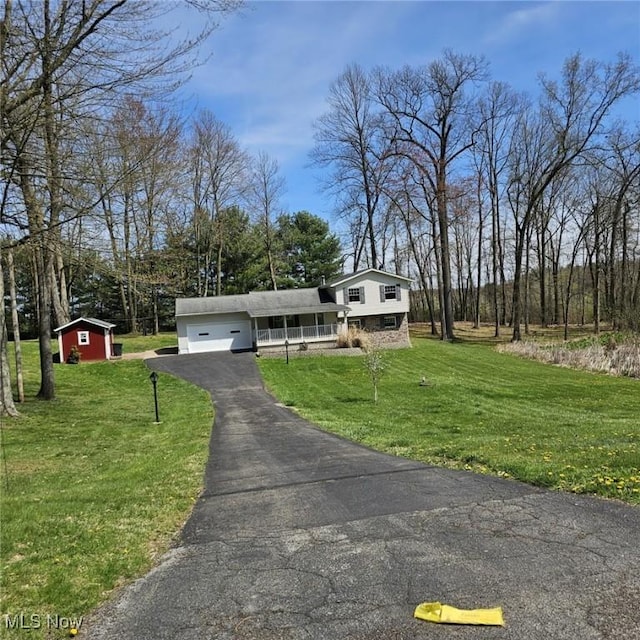 tri-level home with aphalt driveway, a front lawn, and a garage