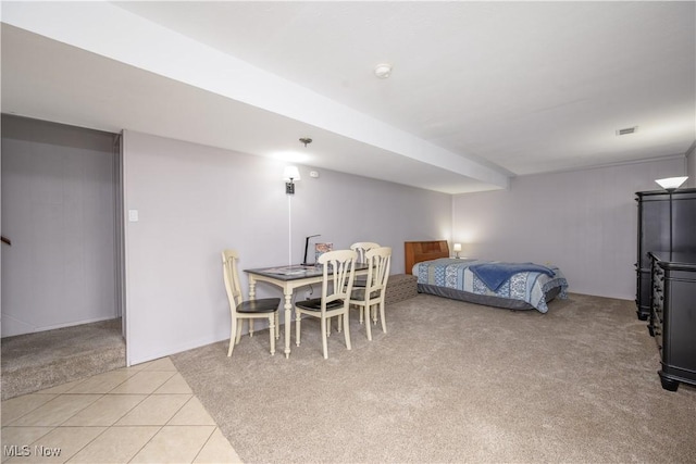 bedroom featuring light tile patterned floors, visible vents, and light colored carpet