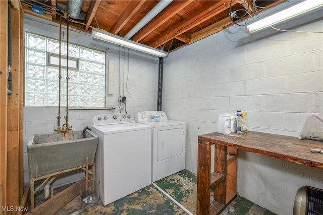 laundry area with laundry area, washing machine and dryer, and a sink