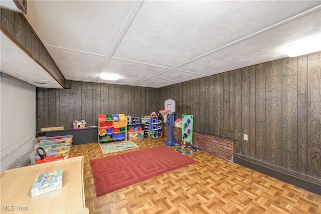 game room with wood walls