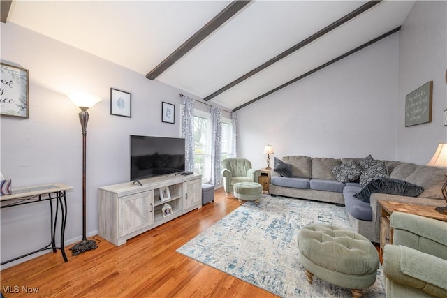 living room featuring baseboards, vaulted ceiling with beams, and light wood-type flooring
