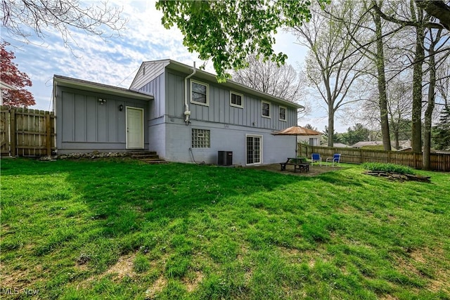 back of property featuring board and batten siding, a fenced backyard, entry steps, and an outdoor fire pit