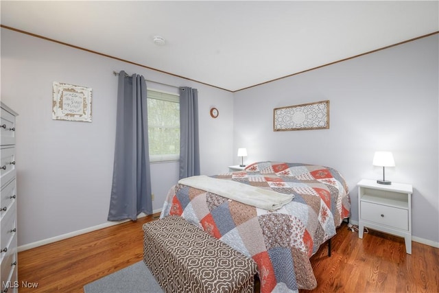 bedroom featuring crown molding, baseboards, and wood finished floors