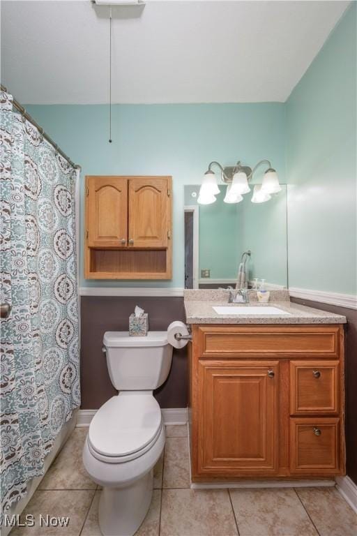 full bath with toilet, tile patterned floors, curtained shower, and vanity