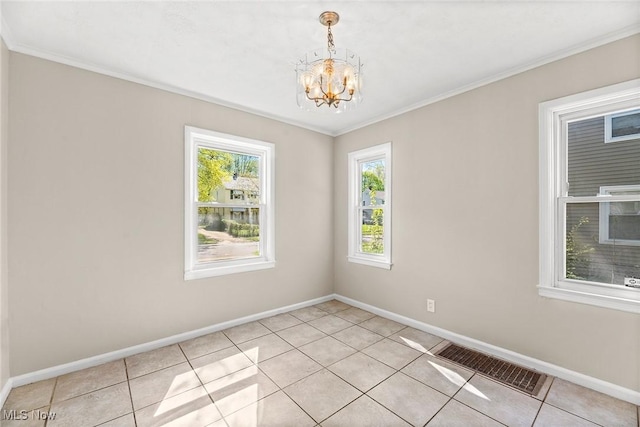 spare room with an inviting chandelier, light tile patterned floors, ornamental molding, and visible vents