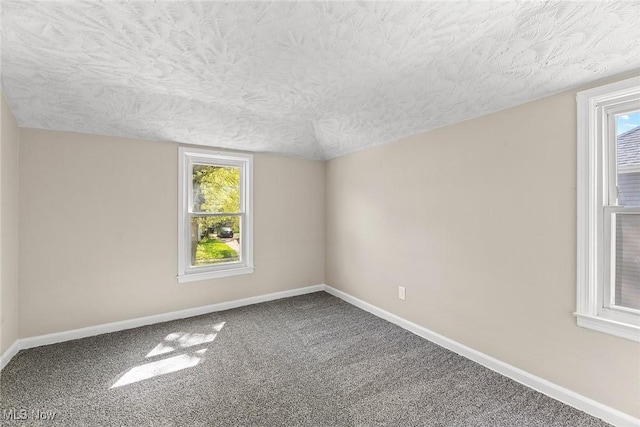 unfurnished room featuring baseboards, carpet, a textured ceiling, and a healthy amount of sunlight