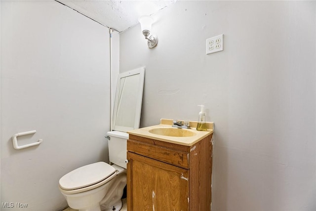 half bathroom with vanity and toilet