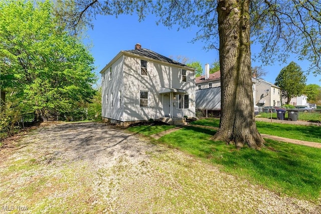 exterior space with a lawn, fence, and a chimney