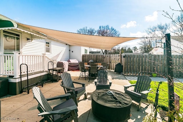 view of patio featuring fence, a fire pit, and outdoor dining area