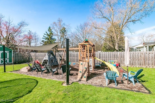 view of jungle gym featuring a fenced backyard, an outbuilding, a shed, and a yard