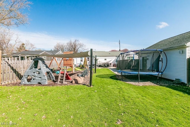 view of yard featuring a playground, fence, and a trampoline