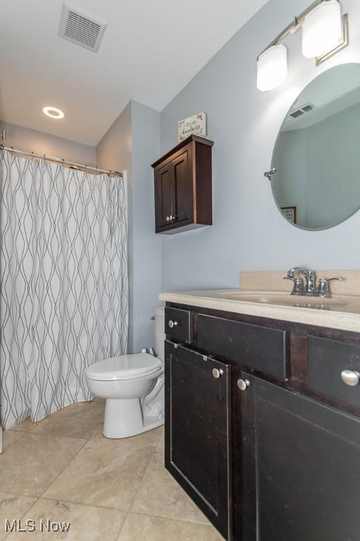 full bath with visible vents, curtained shower, toilet, and vanity