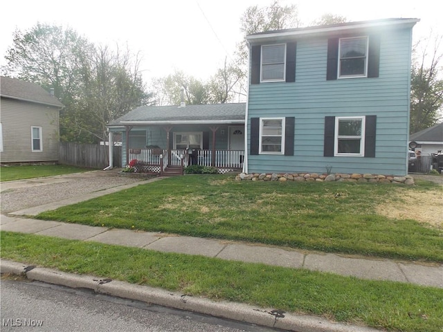 view of front of house with a porch, a front lawn, fence, and gravel driveway