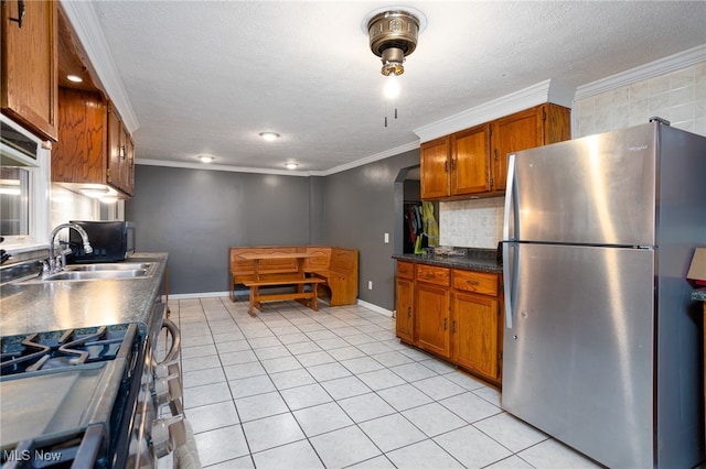 326 N Lyman St, Wadsworth, OH 44281 - kitchen with a sink, tasteful backsplash, brown cabinets, crown molding, and appliances with stainless steel finishes