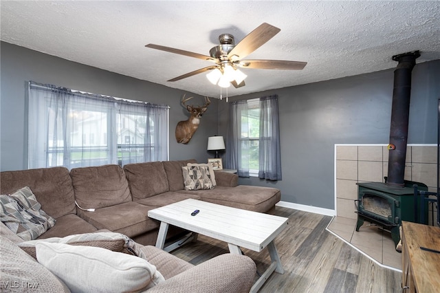 326 N Lyman St, Wadsworth, OH 44281 - living area with wood finished floors, a textured ceiling, baseboards, ceiling fan, and a wood stove