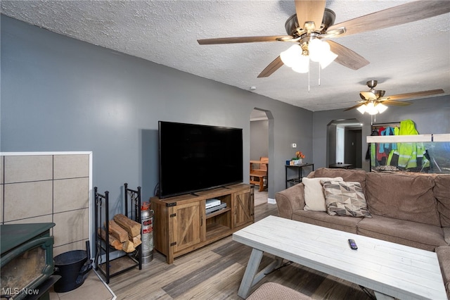 326 N Lyman St, Wadsworth, OH 44281 - living area with wood finished floors, a textured ceiling, ceiling fan, arched walkways, and a wood stove