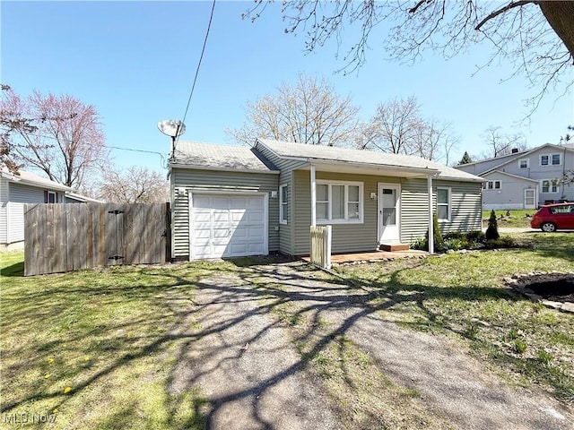 view of front of house with fence, an attached garage, driveway, and a front lawn