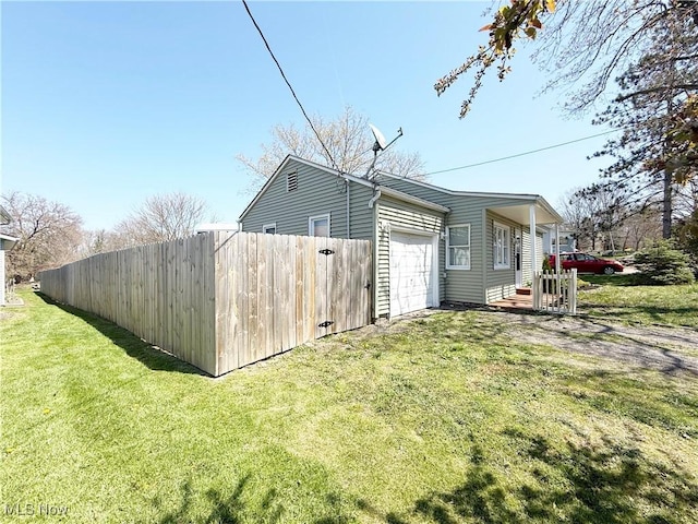 view of property exterior with a garage, fence, a yard, and driveway