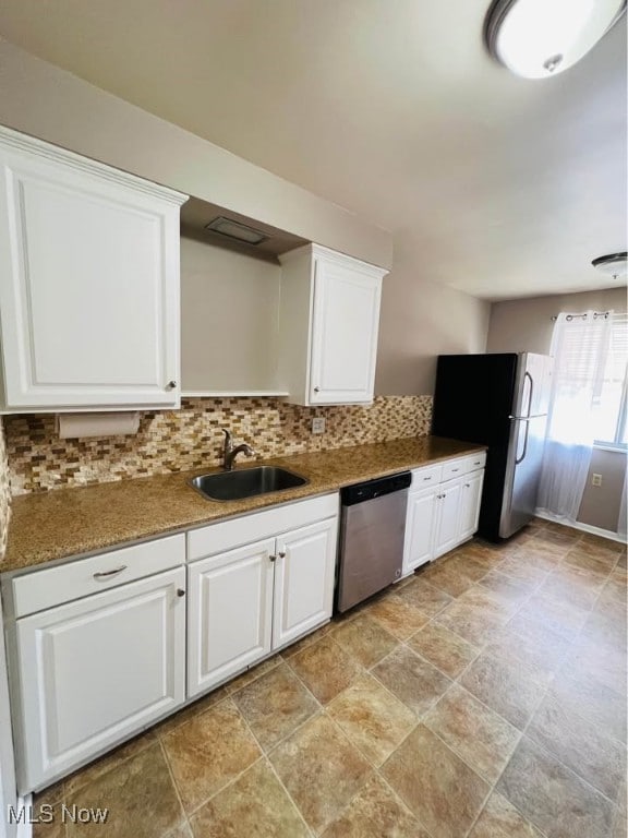 kitchen featuring a sink, white cabinets, stainless steel appliances, and tasteful backsplash