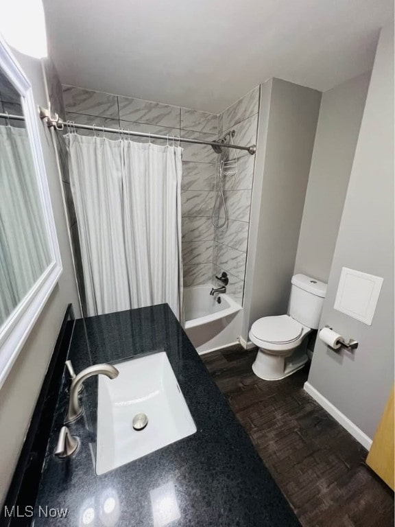 full bath with toilet, baseboards, shower / bathtub combination with curtain, and wood finished floors