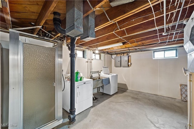 basement with washer and dryer, a sink, and electric panel