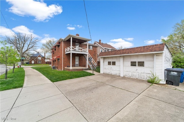 exterior space with a detached garage and a front yard