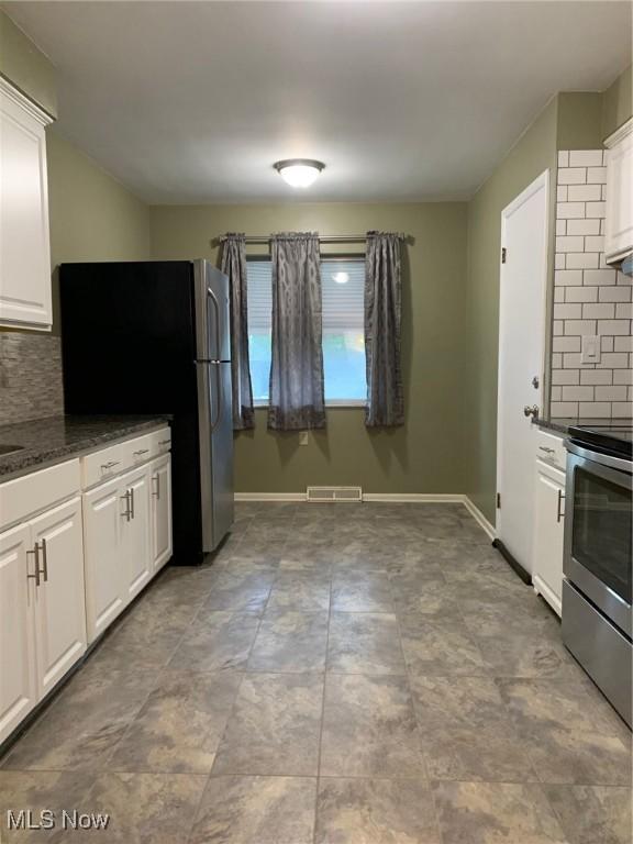 kitchen with appliances with stainless steel finishes, decorative backsplash, white cabinetry, and visible vents
