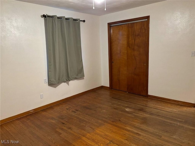 empty room with baseboards and wood finished floors