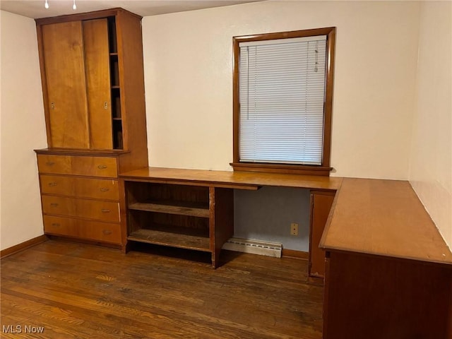 unfurnished office with baseboards, dark wood finished floors, built in desk, and baseboard heating