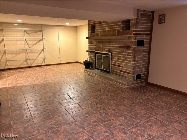 finished basement with baseboards, recessed lighting, and a fireplace