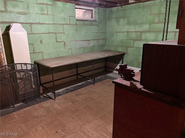 below grade area featuring concrete block wall and tile patterned floors