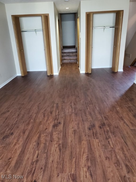 25078 Mill River Rd, Olmsted Falls, OH 44138 - unfurnished bedroom featuring multiple closets, dark wood-type flooring, and baseboards