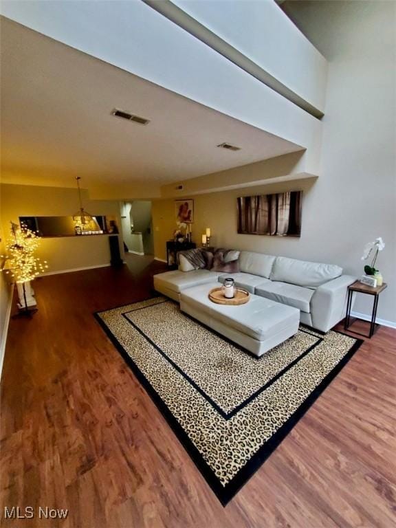 living area featuring baseboards, visible vents, and wood finished floors