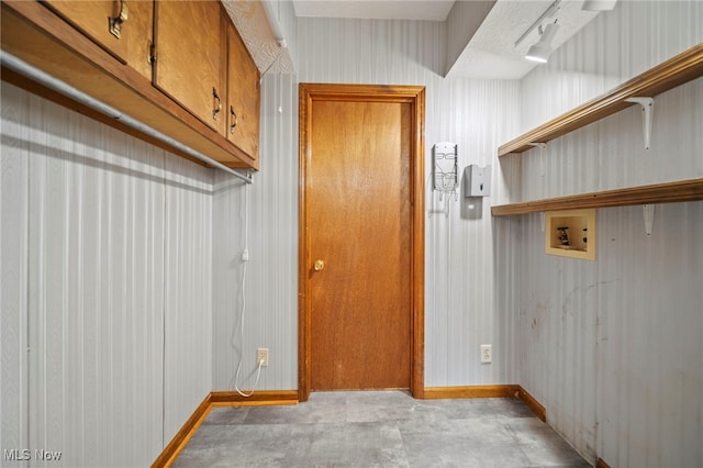 laundry room with washer hookup, baseboards, and cabinet space