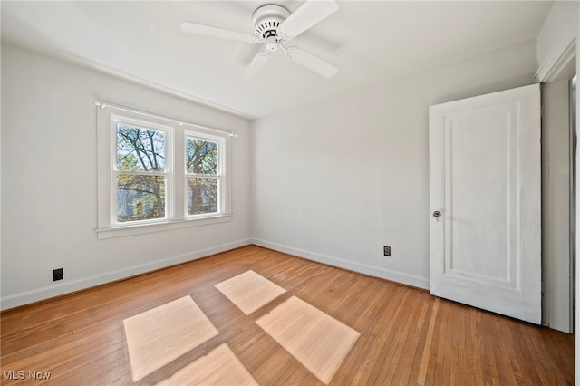 empty room with baseboards, a ceiling fan, and wood finished floors