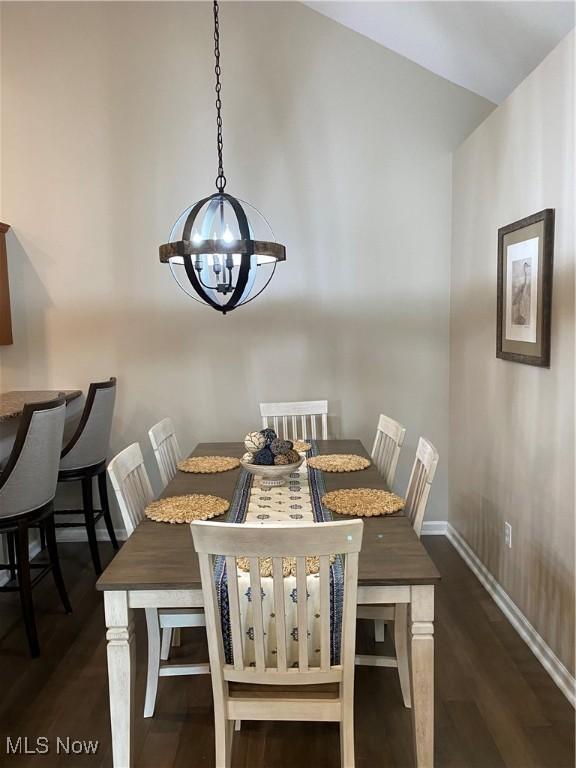 dining room featuring baseboards, dark wood-type flooring, and a notable chandelier