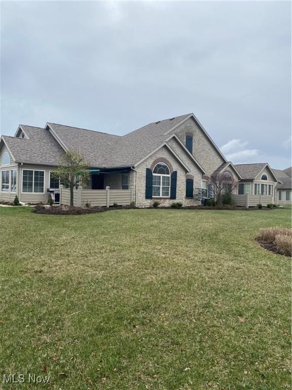 single story home featuring a shingled roof and a front yard