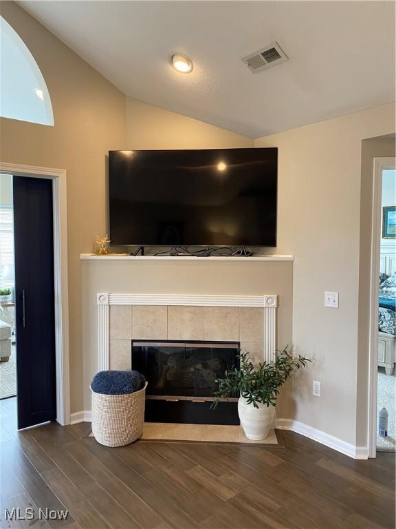 interior details with baseboards, visible vents, wood finished floors, and a fireplace