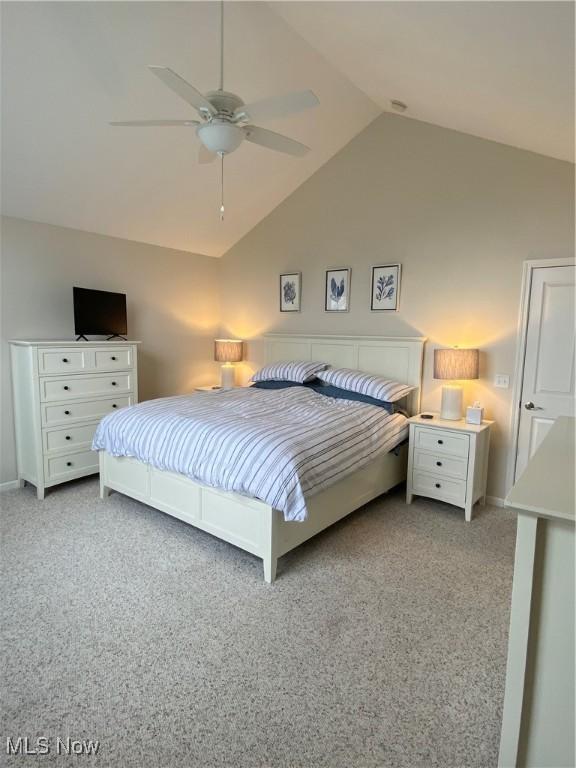 bedroom with baseboards, ceiling fan, light carpet, and lofted ceiling