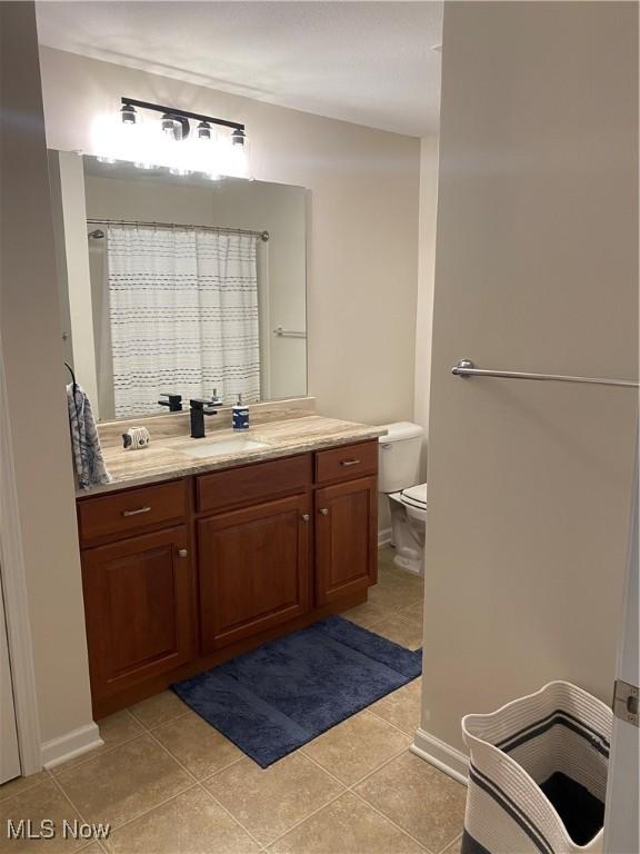 full bath with vanity, toilet, tile patterned floors, baseboards, and a shower with curtain