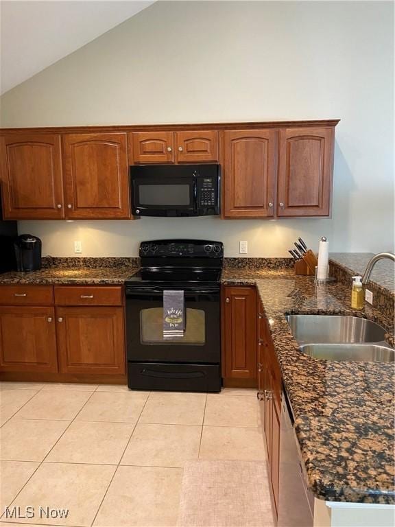 kitchen with a sink, high vaulted ceiling, black appliances, dark stone countertops, and light tile patterned flooring