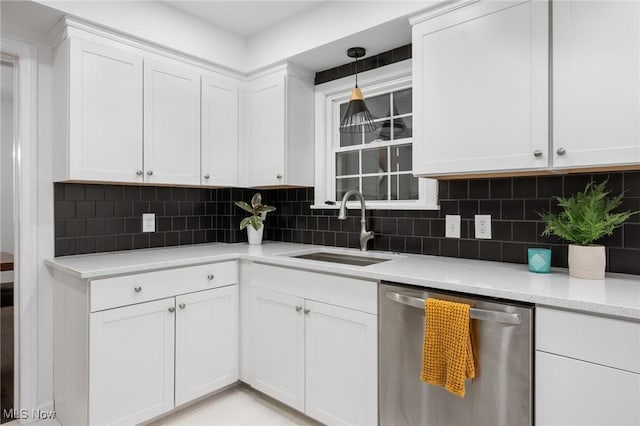kitchen with backsplash, decorative light fixtures, stainless steel dishwasher, a sink, and white cabinetry