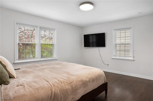 bedroom featuring dark wood-style flooring and baseboards