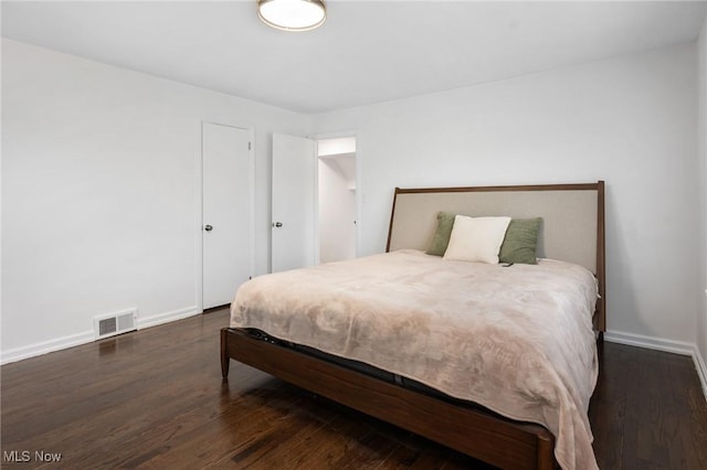 bedroom featuring baseboards, visible vents, and dark wood-style floors