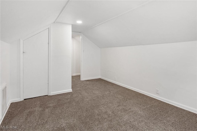 additional living space with carpet flooring, baseboards, and vaulted ceiling