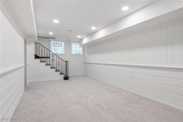 below grade area featuring recessed lighting, baseboards, carpet, and stairs