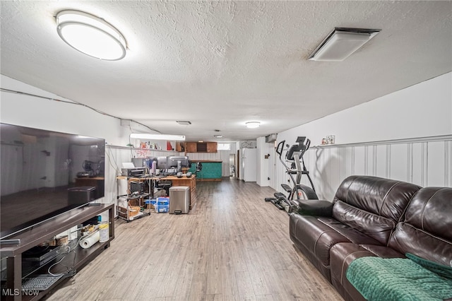 living area with a textured ceiling and wood finished floors