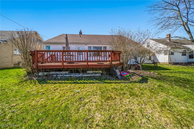back of property featuring a lawn and a deck